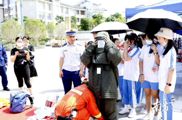 同学们兴致盎然地体验穿脱消防服。段灿摄