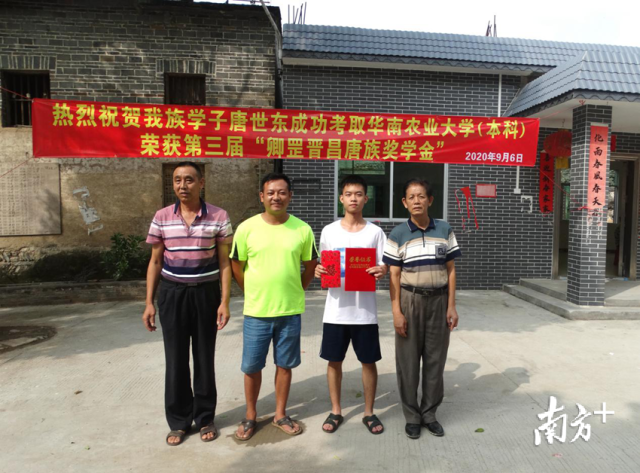 镇龙村奖学基金会对考上华南农业大学的唐世东进行奖励。