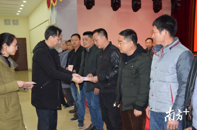 连州镇委书记刘永忠为获表彰的村民小组长颁奖。