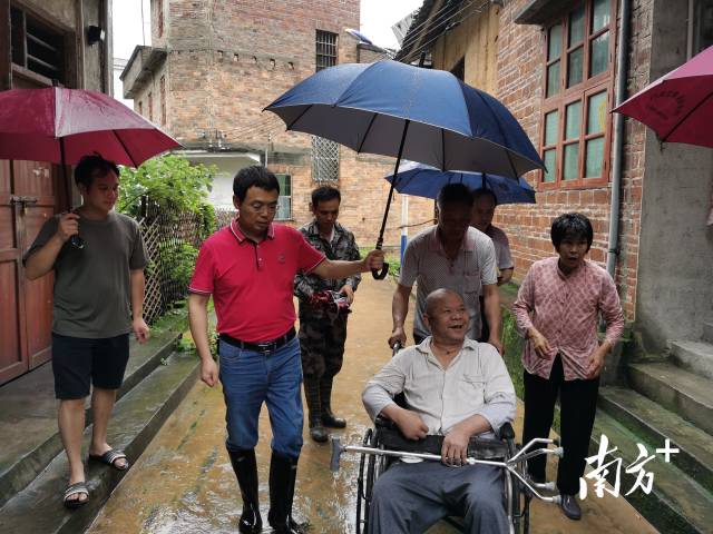 丰阳镇党委书记李剑平协助转移行动不便的困难群众。