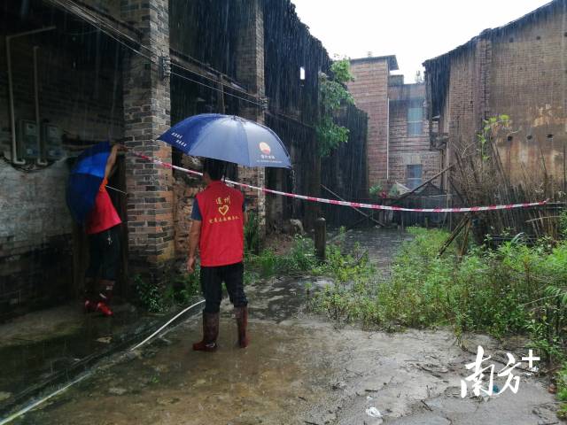 党群志愿者冒雨拉起警戒线。