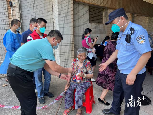 连州市委常委、副市长、九陂镇党委书记綦鸿伟在核酸检测现场协助老人参加核酸检测，为老人做好防暑措施。