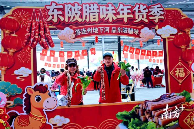 游客与特产东陂腊味、连州菜心打卡拍照。黄滢 摄