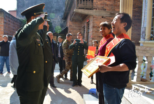 在家门口收到喜报，黄建波夫妻俩笑容灿烂。